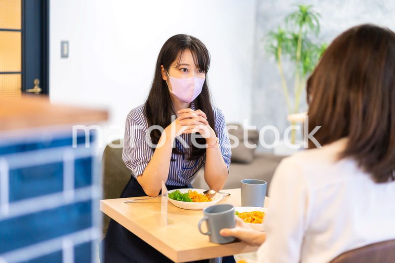 マスクをしてランチをする2人の若い女性
