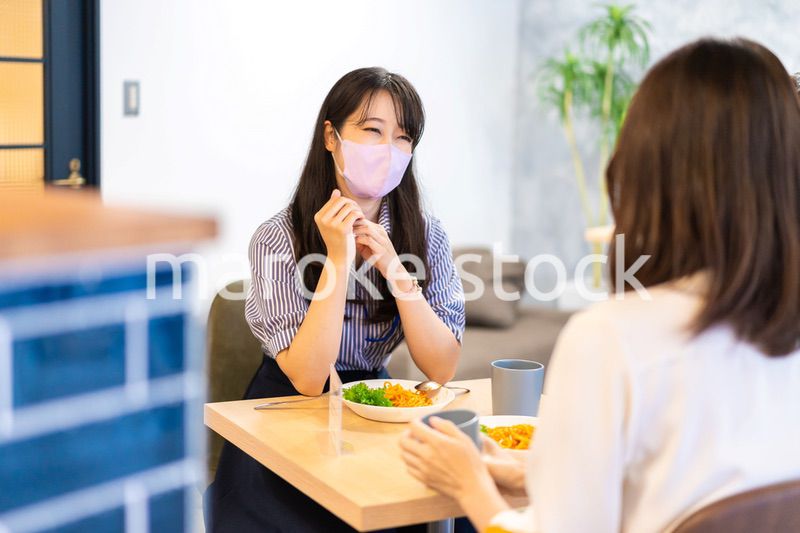 マスクをしてランチをする2人の若い女性