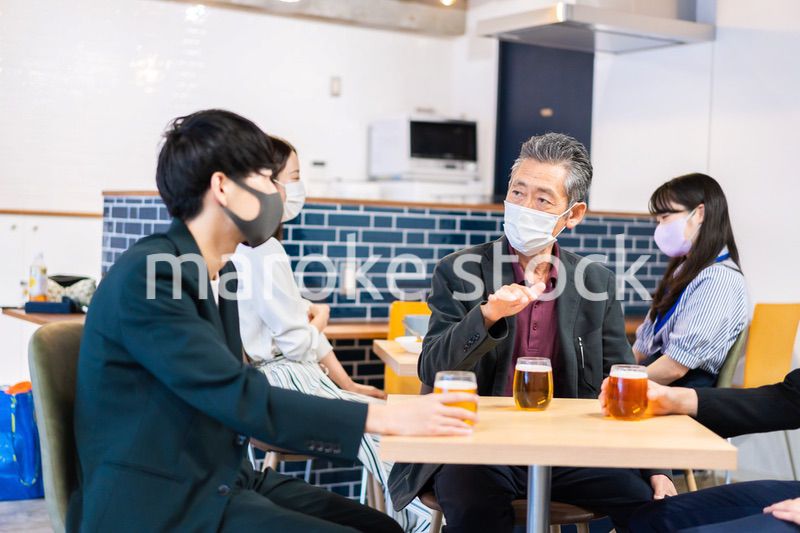 マスクをしてレストランで会話をする人々