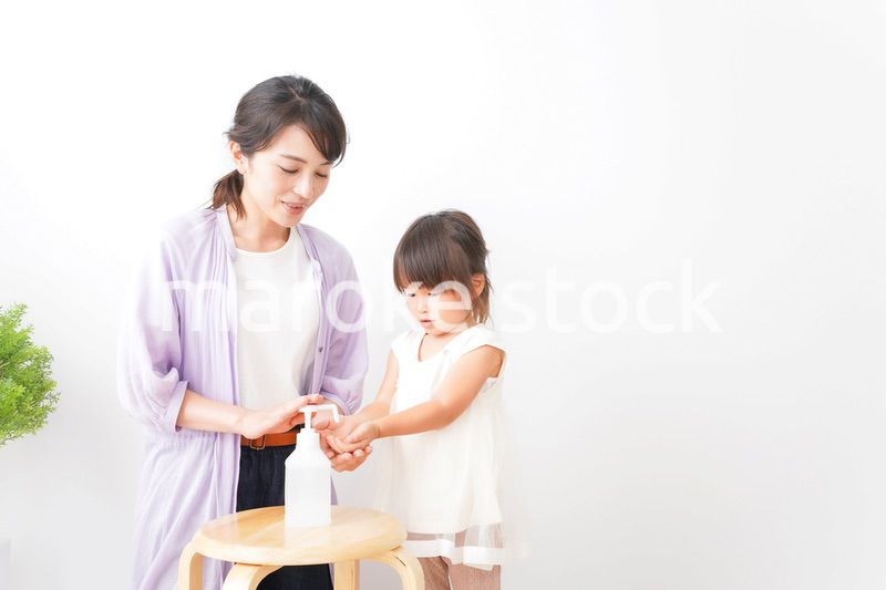 手の消毒をするお母さんと子ども
