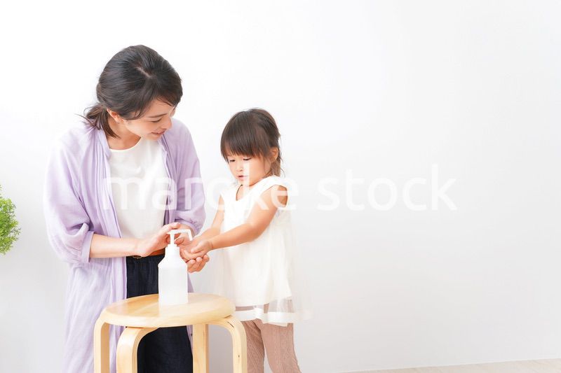 手の消毒をするお母さんと子ども