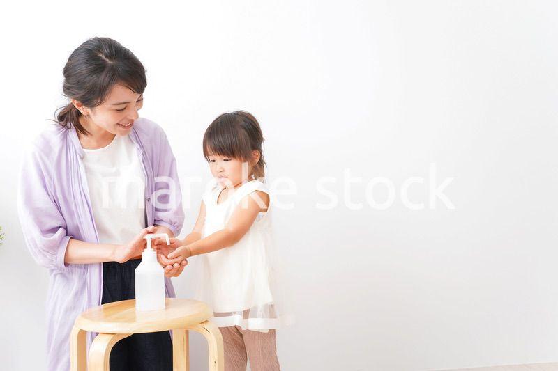 手の消毒をするお母さんと子ども