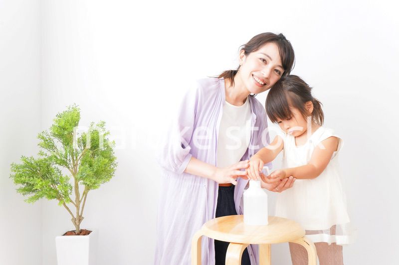 手の消毒をするお母さんと子ども
