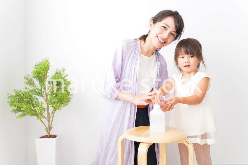 手の消毒をするお母さんと子ども