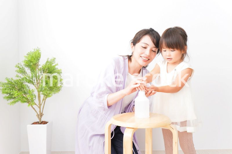 手の消毒をするお母さんと子ども