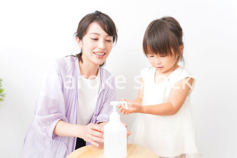 手の消毒をするお母さんと子ども