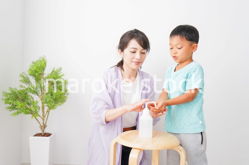 手指の消毒をする親子