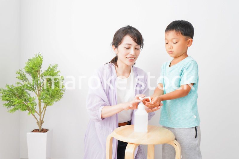 手指の消毒をする親子