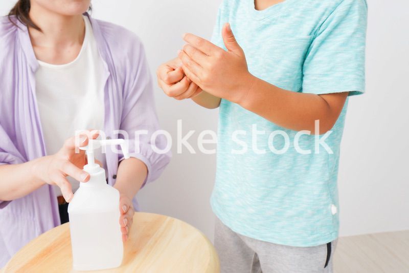 手指の消毒をする親子