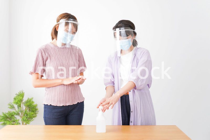 フェイスシールドをして話す若い女性