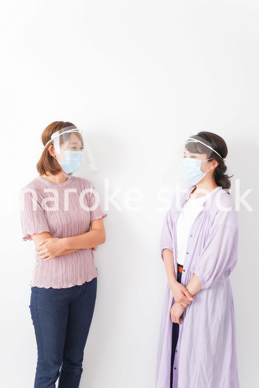 フェイスシールドをして話す若い女性