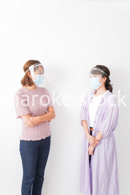 フェイスシールドをして話す若い女性