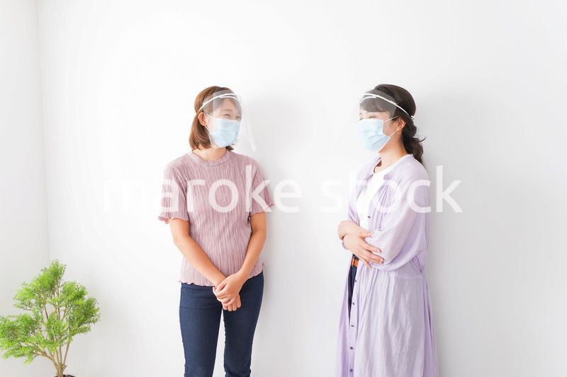 フェイスシールドをして話す若い女性