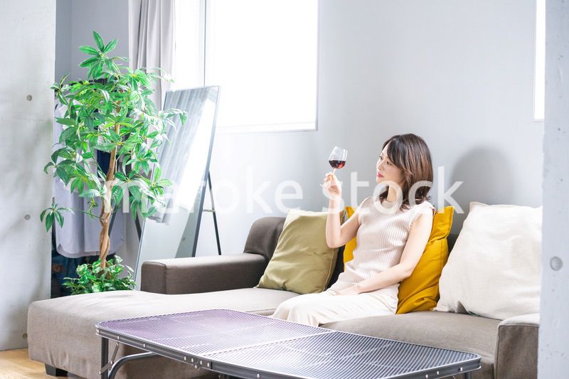 家でワインを楽しむ若い女性