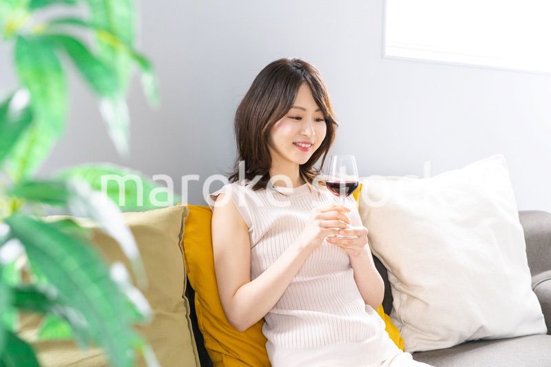 家でワインを楽しむ若い女性