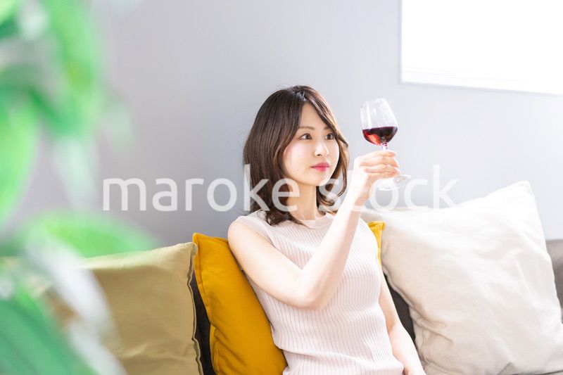 家でワインを楽しむ若い女性