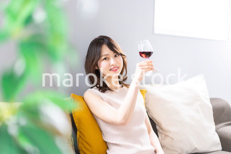 家でワインを楽しむ若い女性