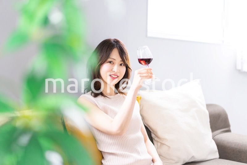 家でワインを楽しむ若い女性