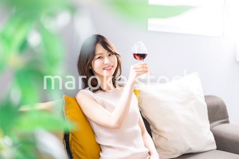 家でワインを楽しむ若い女性