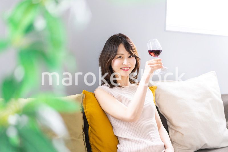 家でワインを楽しむ若い女性