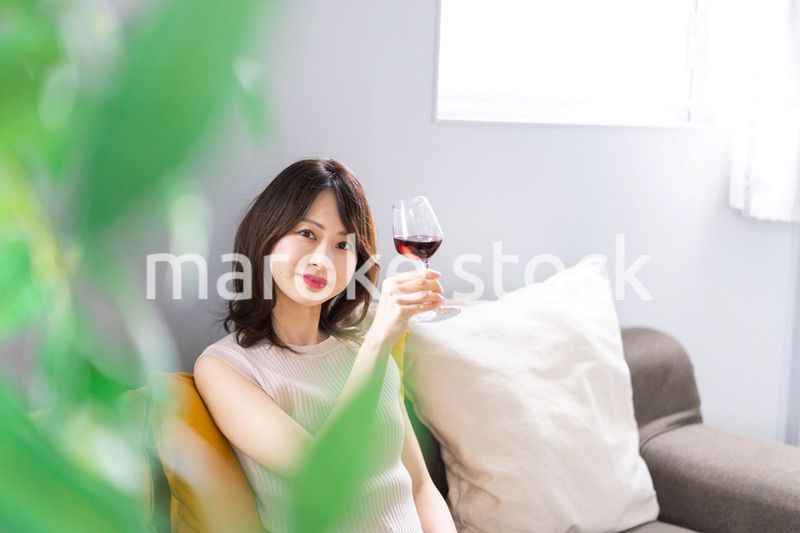 家でワインを楽しむ若い女性