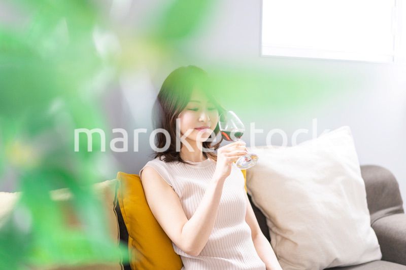 家でワインを楽しむ若い女性