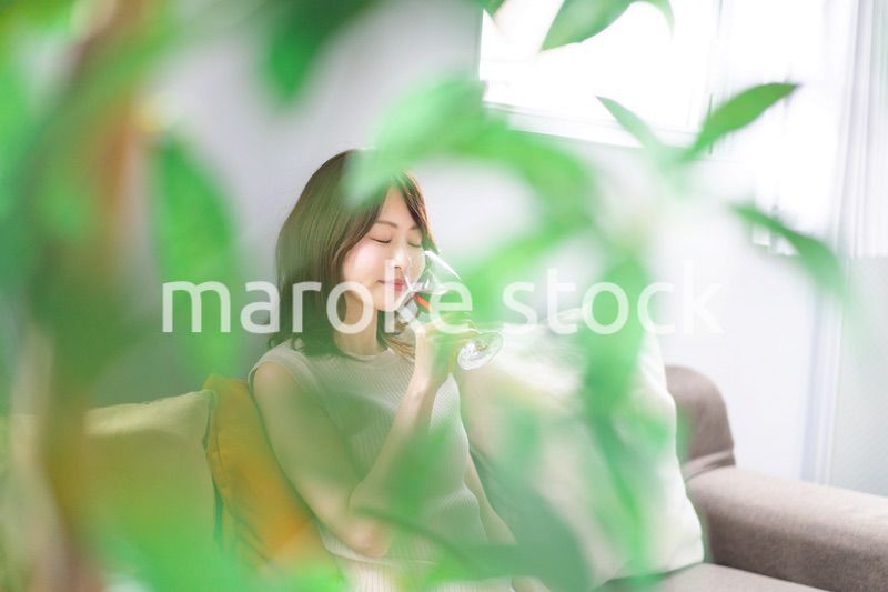 家でワインを楽しむ若い女性