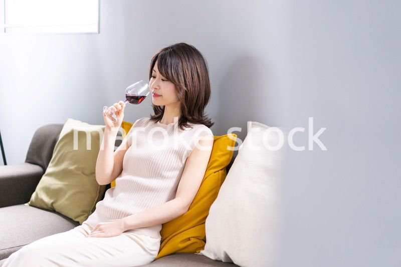 家でワインを楽しむ若い女性