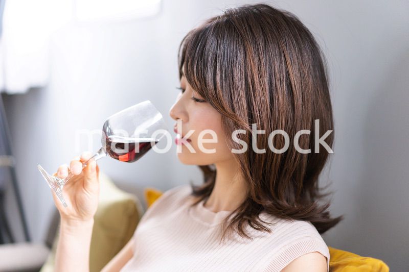 家でワインを楽しむ若い女性