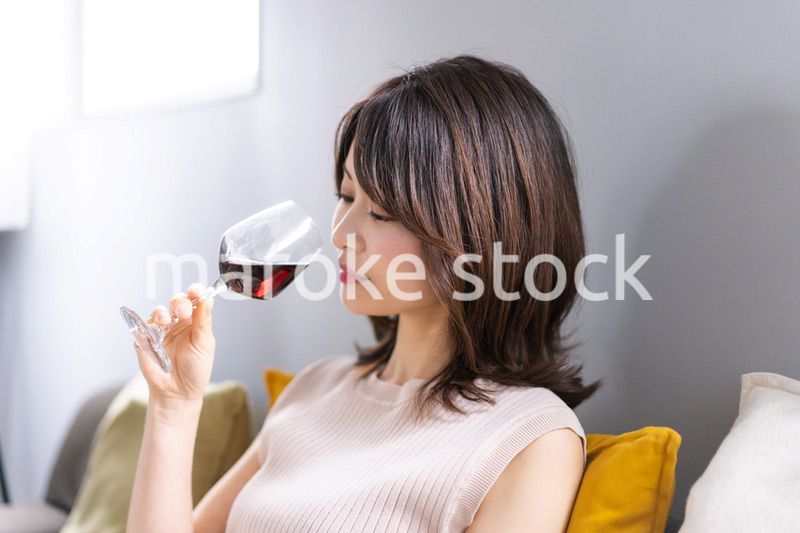 家でワインを楽しむ若い女性