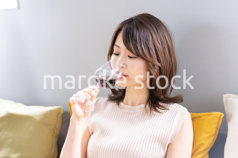 家でワインを楽しむ若い女性