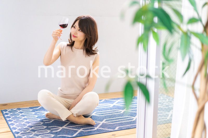 家でワインを楽しむ女性