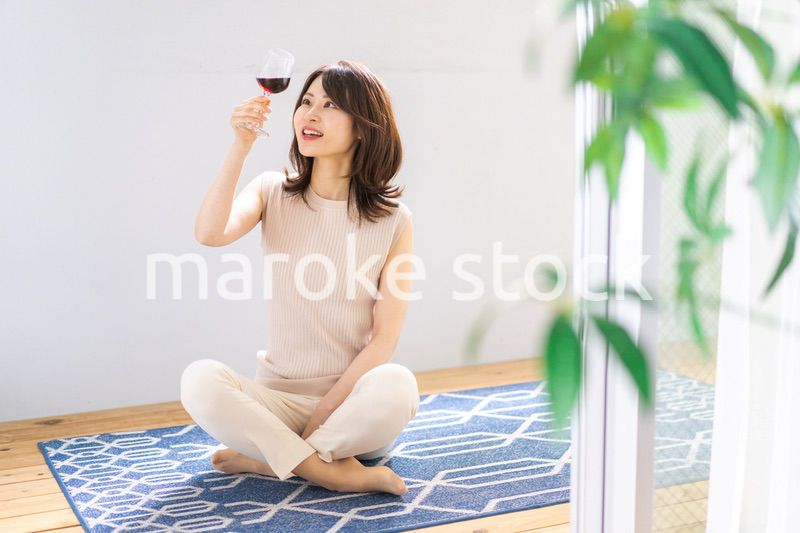 家でワインを楽しむ女性