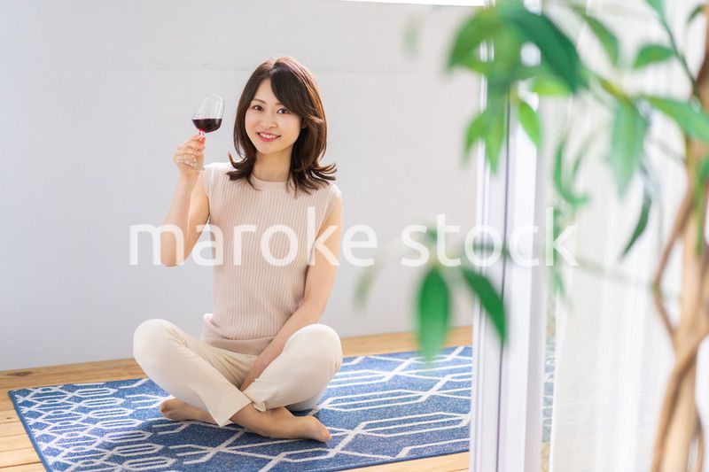 家でワインを楽しむ女性