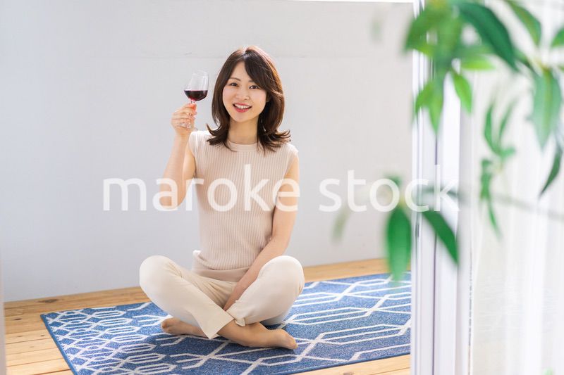 家でワインを楽しむ女性