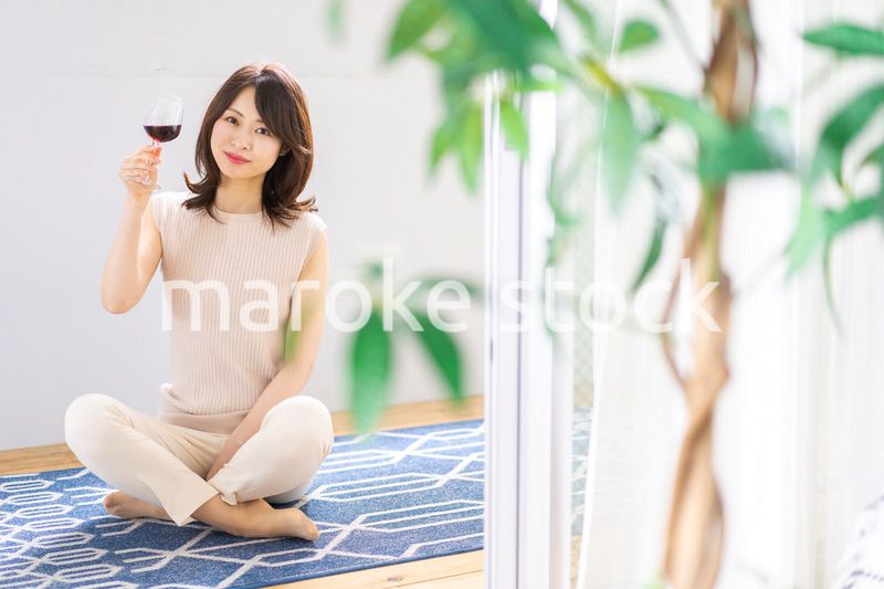 家でワインを楽しむ女性