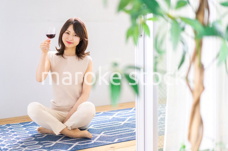 家でワインを楽しむ女性