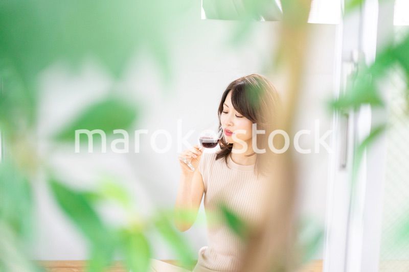 家でワインを楽しむ女性