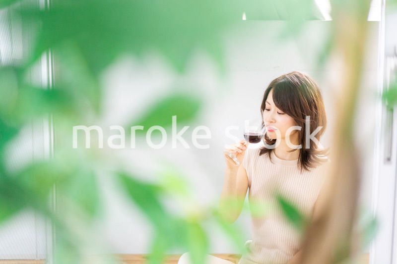 家でワインを楽しむ女性