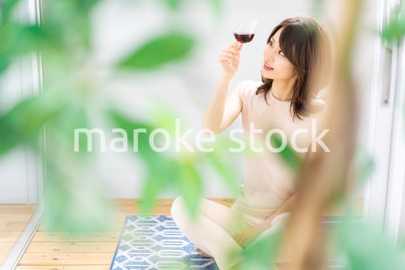 家でワインを楽しむ女性