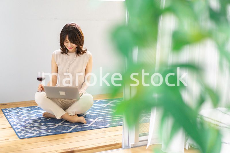 ワインを飲みながらビデオチャットをする若い女性