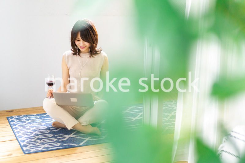 ワインを飲みながらビデオチャットをする若い女性