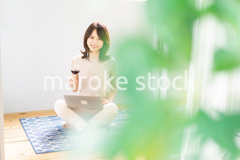 ワインを飲みながらビデオチャットをする若い女性