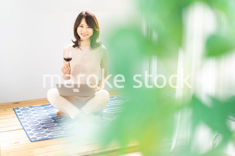 ワインを飲みながらビデオチャットをする若い女性