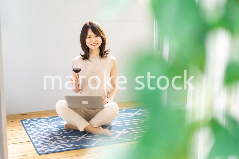 ワインを飲みながらビデオチャットをする若い女性