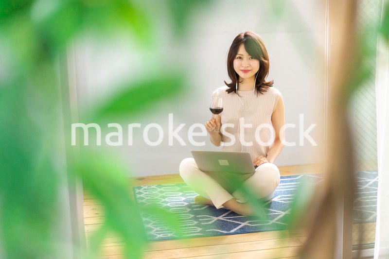 ワインを飲みながらビデオチャットをする若い女性