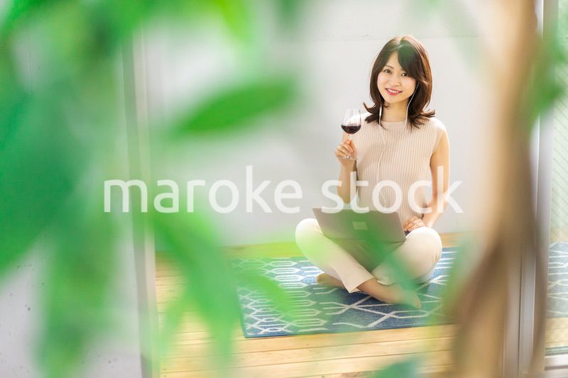 ワインを飲みながらビデオチャットをする若い女性