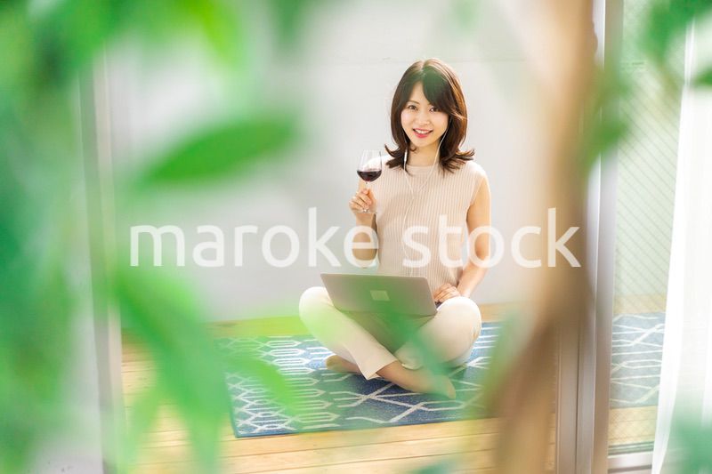 ワインを飲みながらビデオチャットをする若い女性
