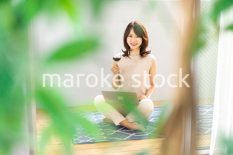 ワインを飲みながらビデオチャットをする若い女性