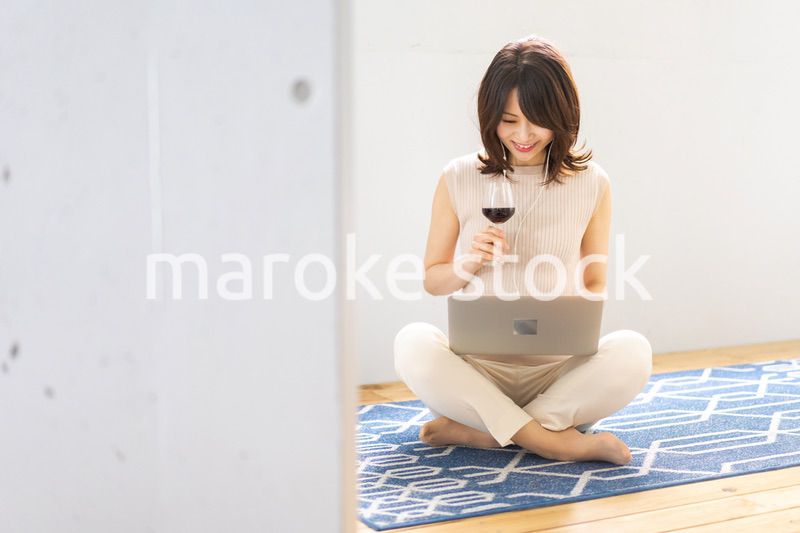 ワインを飲みながらビデオチャットをする若い女性